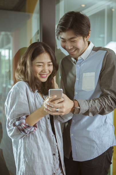 Asya genç erkek ve kadın mutlu f ile akıllı telefon izlerken - Fotoğraf, Görsel