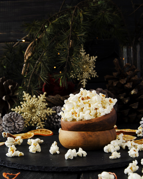 Popcorn in een houten plaat op de achtergrond van Kerstmis - Foto, afbeelding