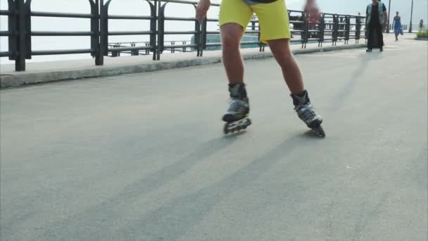Mans legs roller skating inline close up on the waterfront - Filmmaterial, Video