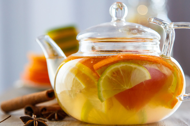 Tè in una teiera di vetro di arancia, limone, lime, cannella e stella
  - Foto, immagini
