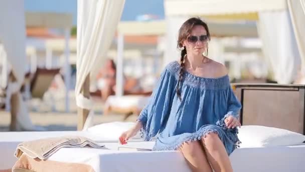 junge Frau während eines tropischen Strandurlaubs. Modemädchen in weißen Sonnenliegen am europäischen Strandwochenende - Filmmaterial, Video