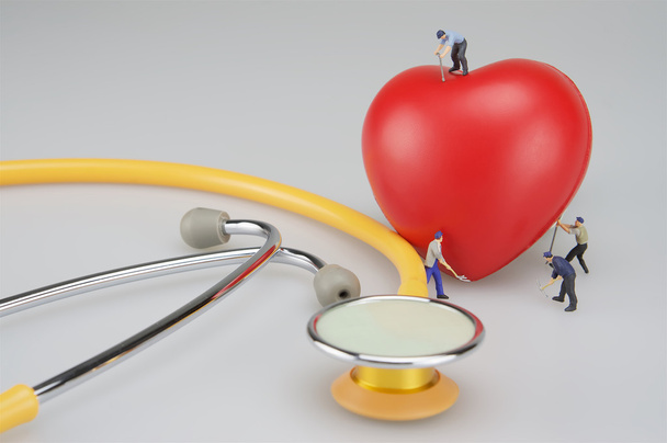 Personas en miniatura cuidan el corazón y el estetoscopio
 - Foto, Imagen