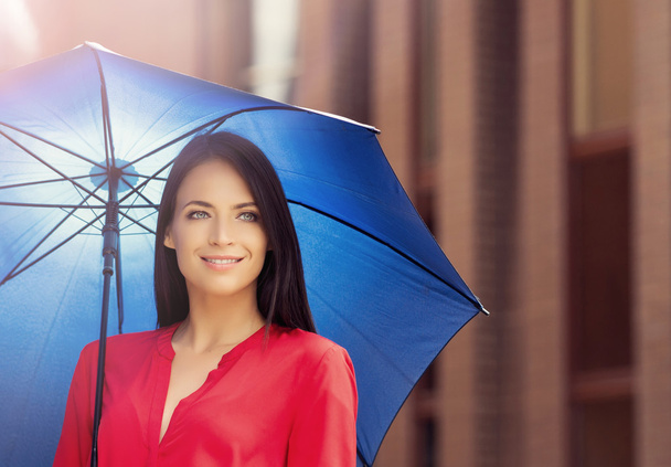 Young and happy woman under blue umbrella - Foto, Imagen