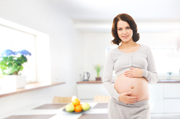 Pregnant woman at modern kitchen - Foto, afbeelding