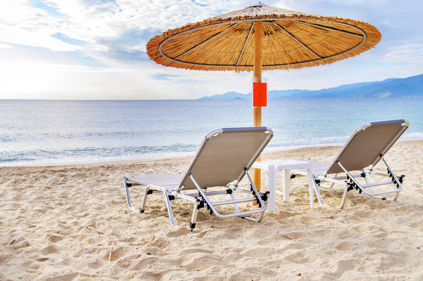 Γκρίζο άχυρο ομπρέλα στην όμορφη παραλία και τον ωκεανό φόντο - Φωτογραφία, εικόνα