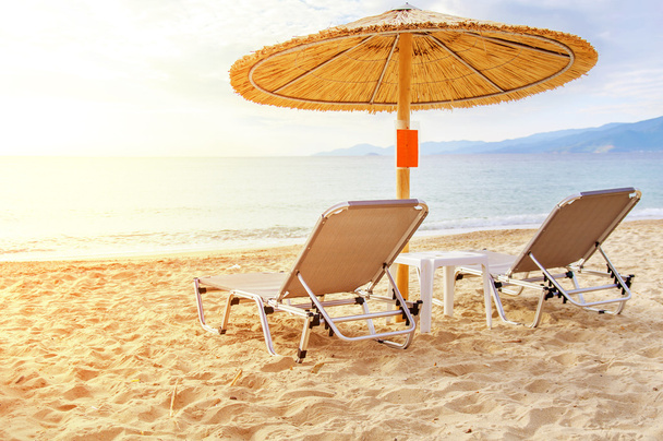美しいビーチと太陽の燃焼と海に灰色藁傘 - 写真・画像