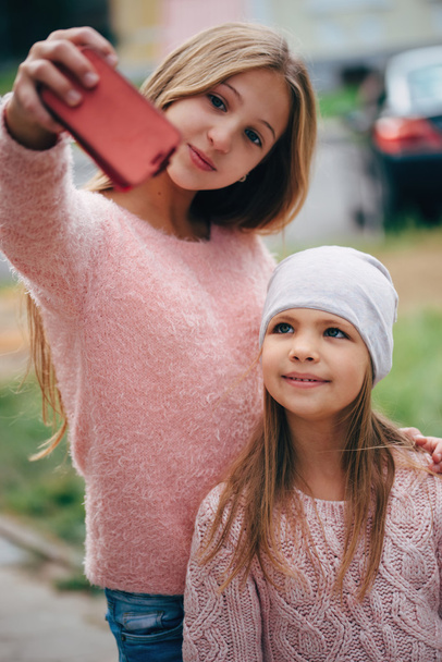 two beautiful little girls making selfie - 写真・画像