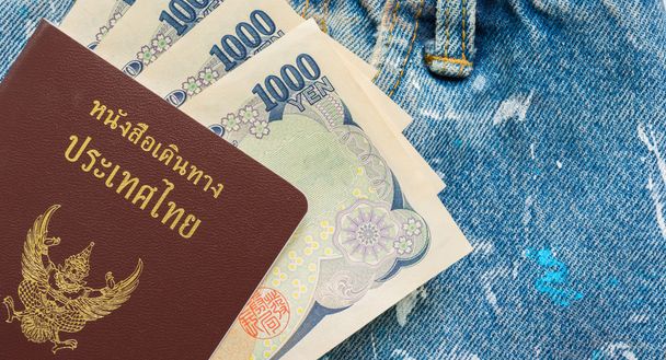 Тайский паспорт и иены деньги в синих джинсах карманы, мошенник путешественник
 - Фото, изображение