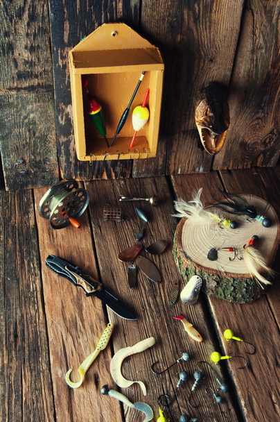 ヴィンテージの木製の背景に釣り道具 - 写真・画像