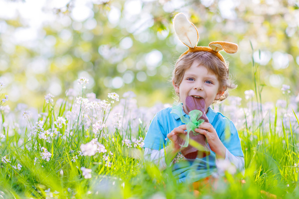 Malé dítě s velikonoční zajíček uši a čokoládou - Fotografie, Obrázek