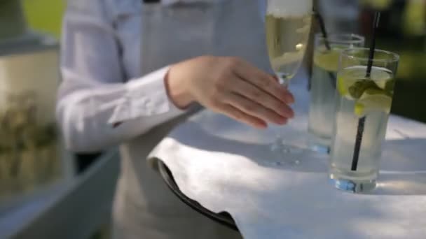 Официант в белой рубашке несет лимонад и шампанское
 - Кадры, видео