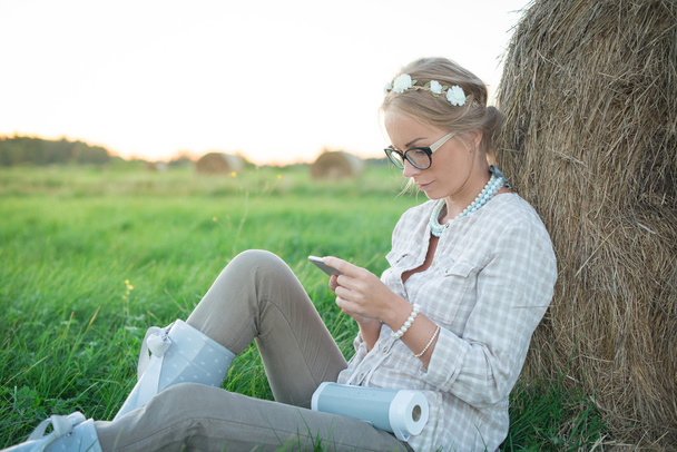 Beautiful young woman listening to the music in the meadow - Foto, Bild