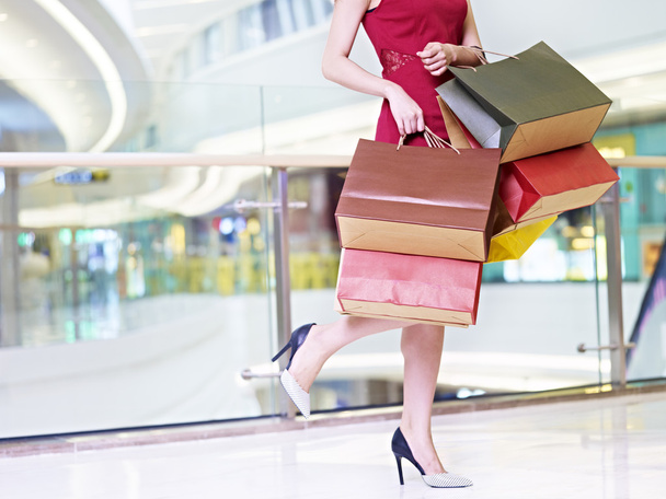 Молодая женщина с разноцветными бумажными пакетами ходить по магазинам Мал
 - Фото, изображение