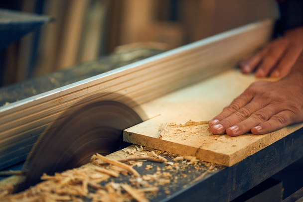 Carpenter cutting wooden plank - Zdjęcie, obraz