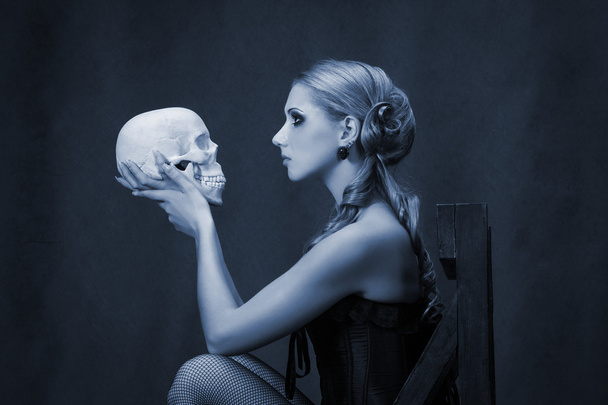 Hermosa mujer con un cráneo retrato bajo llave
  - Foto, imagen