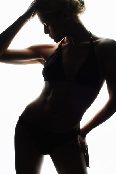 female silhouette.young woman in bikini.girl with a sports body - 写真・画像