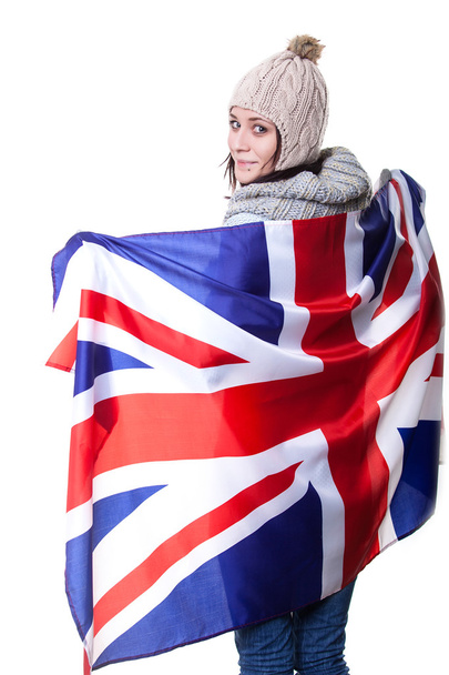 Portrait of a beautiful British girl smiling holding up the UK flag. Isolated on white. - Фото, изображение