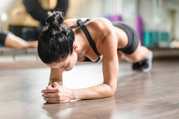 Женщина-атлет делает упражнения на доске
 - Фото, изображение