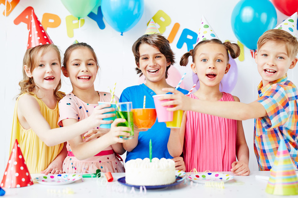 Kids toasting with drinks at birthday party - 写真・画像