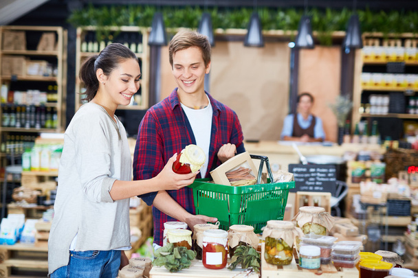 Szczęśliwa para wybierając ogórki w supermarkecie - Zdjęcie, obraz