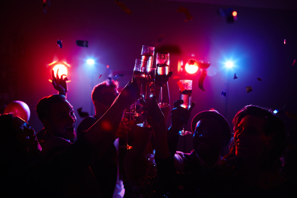 Радостные люди тостуют в ночном клубе
  - Фото, изображение