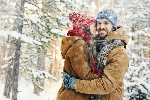 Gelukkige kerel omarmen van zijn vriendin in sneeuwval - Foto, afbeelding