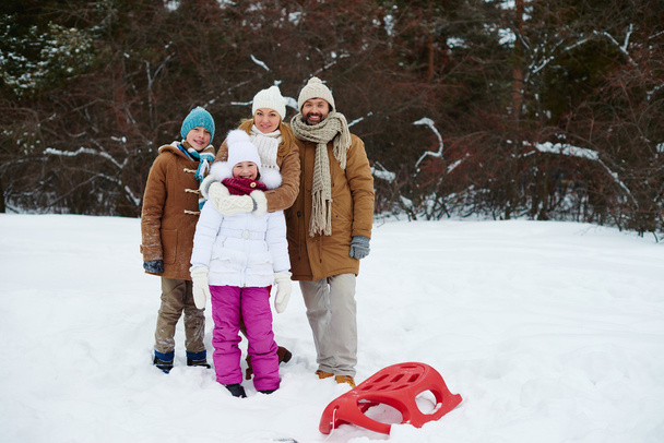 自然環境の中の雪の吹きだまりに家族の立っています。  - 写真・画像