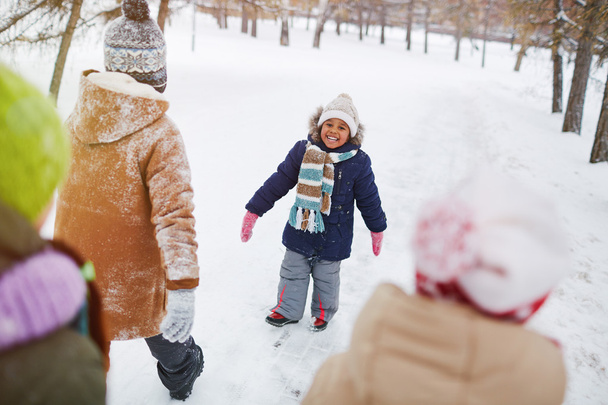 Экстатичный ребенок в зимней одежде смотрит в камеру
 - Фото, изображение