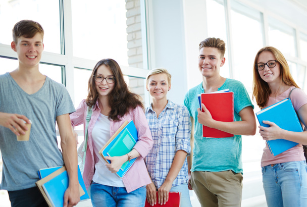 Happy teens with copybooks standing in row  - Foto, Bild