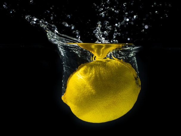 Limón amarillo en agua salpicada
 - Foto, Imagen