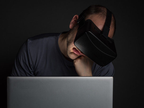 Uomo stanco dipendente dalla tecnologia utilizzando cuffie realtà virtuale
  - Foto, immagini