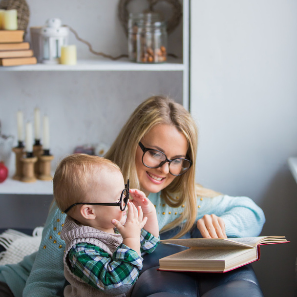 Mother and her son reading book at home - Foto, imagen