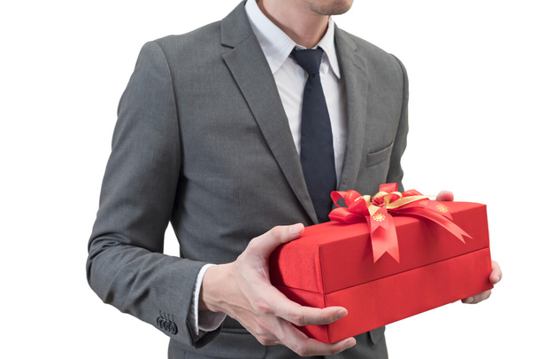 Businessman holding a red giftbox  isolated on white background. - Фото, изображение
