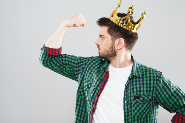 Man in crown showing strength - Zdjęcie, obraz