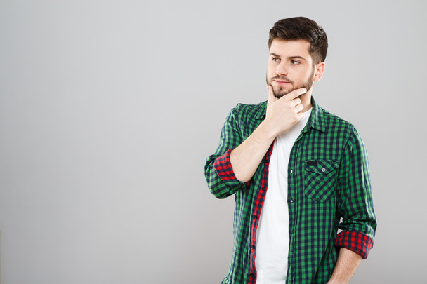 Thoughtful man in green and red checked t-shirt  - Foto, Bild