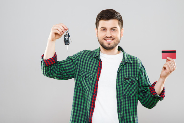 赤いクレジット カード、車のキーを保持している男  - 写真・画像