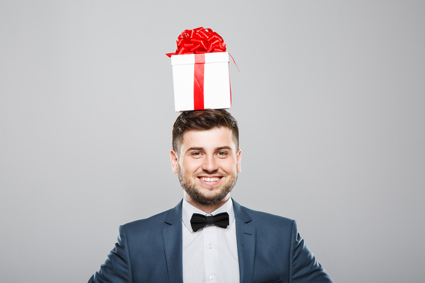 Man in suit with birthday present on head - Valokuva, kuva