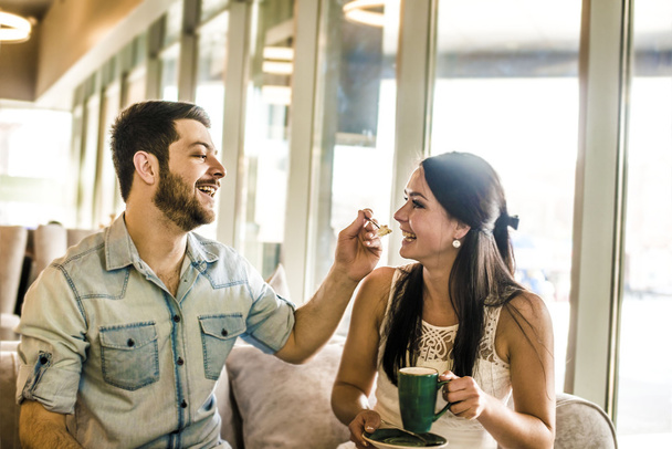 man feeding a biscuit to his girl friend  - Photo, Image