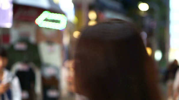 Harajuku éjjel. Emberek séta Takeshita street híres mérföldkő utca, Tokyo, Japán, az esti órákban, neon fénnyel - Felvétel, videó