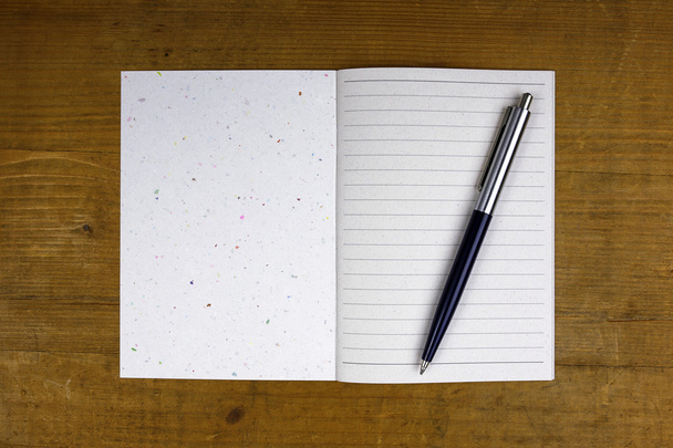 caneta em caderno aberto sobre fundo de madeira
 - Foto, Imagem