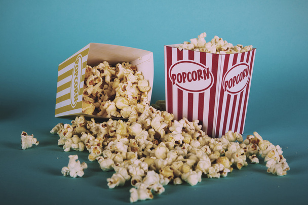 Popcorn ämpäri sinistä taustaa vasten Vintage Retro Filter
. - Valokuva, kuva