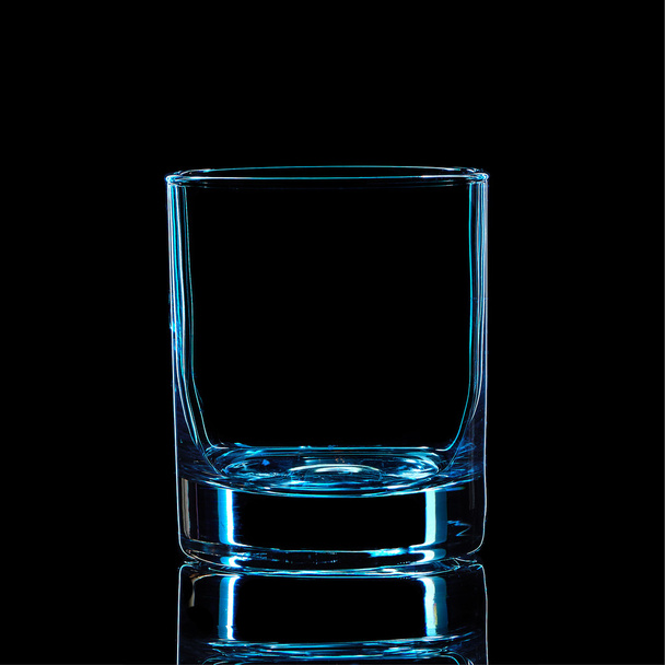 Silhouette of blue strong liquor classic glass on black background - Foto, imagen