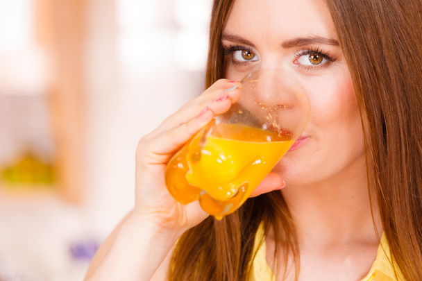 Woman in kitchen drinking fresh orange juice  - Zdjęcie, obraz