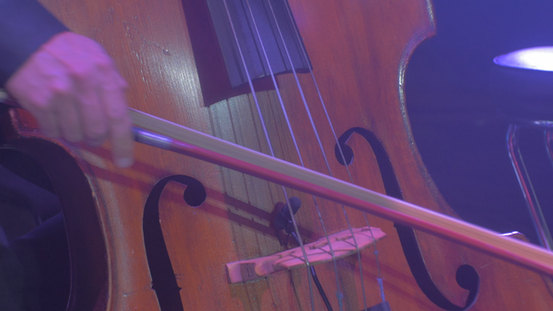 Manos de hombre tocando violonchelo con arco músico bien vestido en esmoquin Hermoso instrumento de cuerda de madera Concierto sinfónico de rock Orquesta sinfónica de Kiev
 - Metraje, vídeo