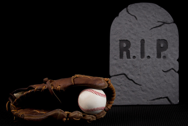 erfahrene Leder-Baseballhandschuh mit Ball isoliert auf schwarzem Hintergrund. Schlechte Saison oder Team im Abschwung. - Foto, Bild