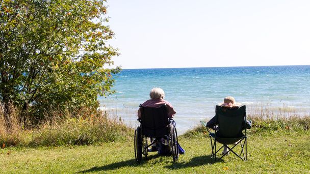 Due anziani seduti sulla spiaggia
. - Foto, immagini