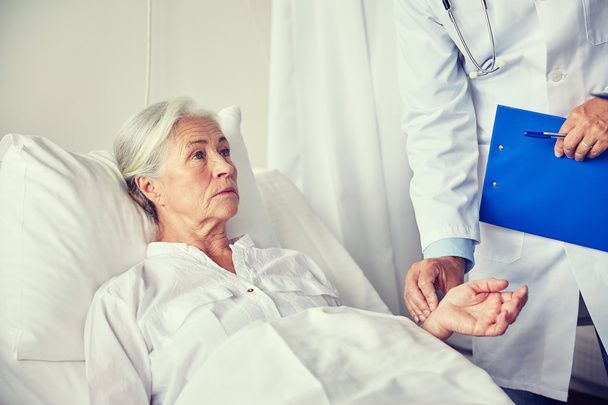 Arzt überprüft Puls der Seniorin im Krankenhaus - Foto, Bild