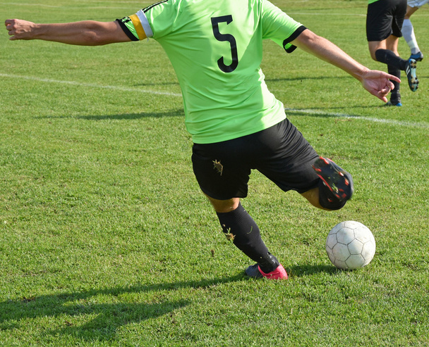 Le footballeur donne un coup de pied au ballon
 - Photo, image
