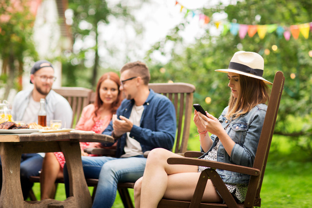 woman with smartphone and friends at summer party - Fotoğraf, Görsel