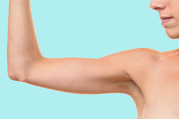 Young blond woman showing flabby arm - Photo, Image